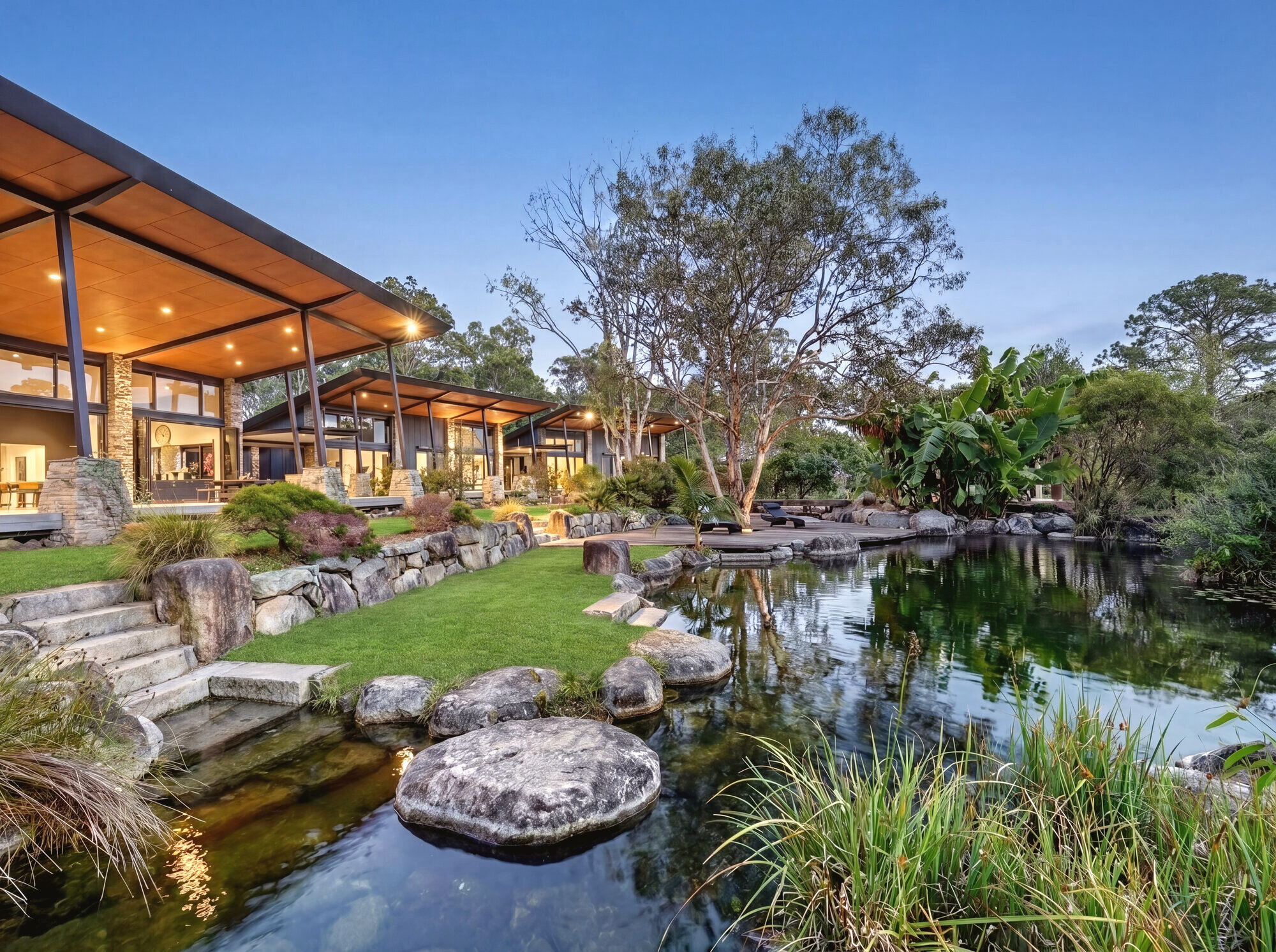 Architectural timber pavilion and gardens at dusk, Gumdale